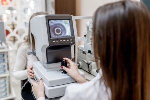 female doctor testing person for her eyes with special optical apparatus in modern clinic.