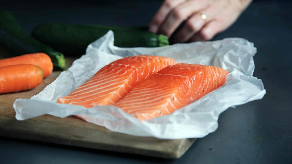 Picture of uncooked salmon on a baking tray. Salmon (omega 3) improves eye health.